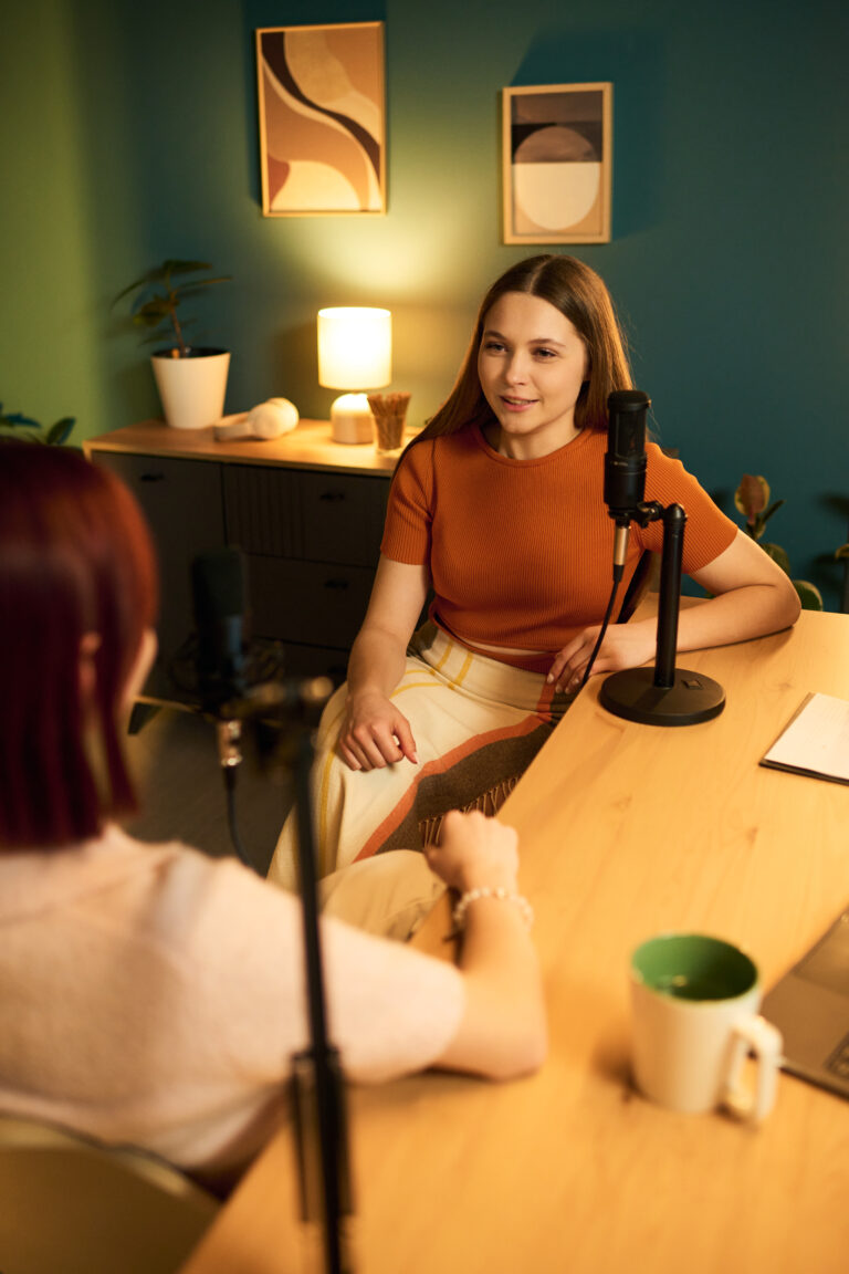 caucasian teenage girls engaging in podcast dialogue using microphones indoors